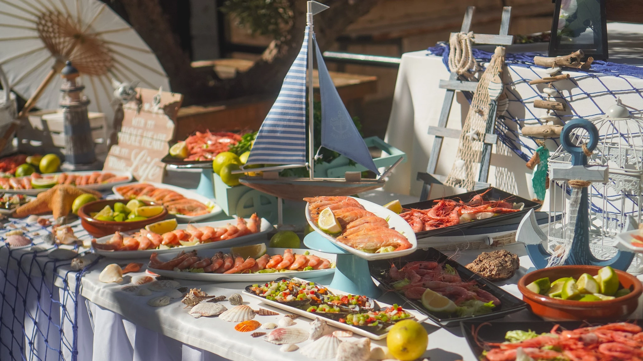 Estación de marisco con langostinos y gambas entre detalles marineros